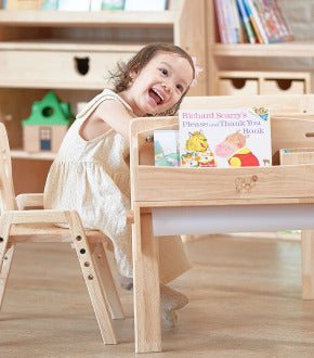 Child sitting at a wooden chair 